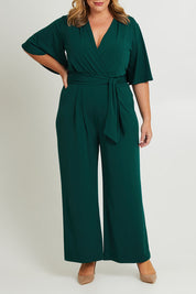 Model Fiona wearing size 16 of The Bell Sleeve Jumpsuit in colour Pine (Green), from the front, cropped image