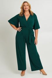 Model Fiona wearing size 16 of The Bell Sleeve Jumpsuit in colour Pine (Green), from the front, showing the whole outfit