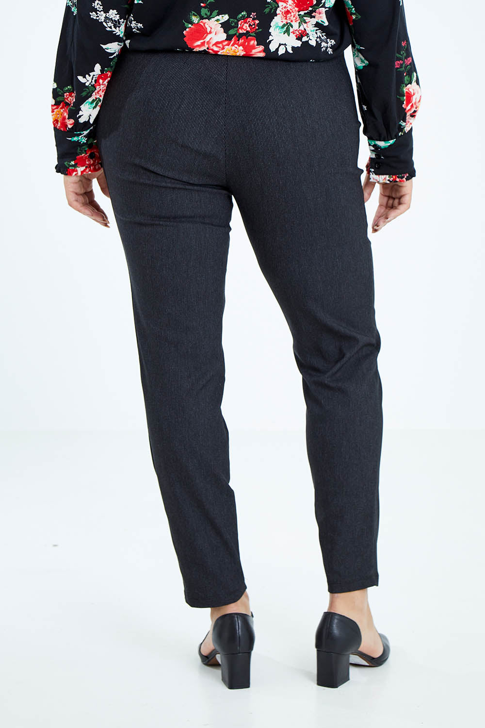 Model Sasha-Lee wearing size 16 of The Stretch Tapered Pull On Pant in colour Black (Black), from the back