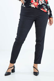 Model Sasha-Lee wearing size 16 of The Stretch Tapered Pull On Pant in colour Black (Black), from the front, cropped image