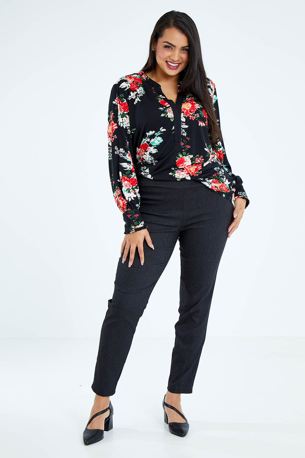 Model Sasha-Lee wearing size 16 of The Stretch Tapered Pull On Pant in colour Black (Black), from the front, showing the whole outfit