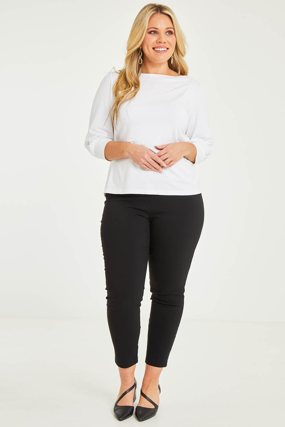 Model Katie wearing size 16 of The Stretch Career Pull On Pant in colour Black (Black), from the front, showing the whole outfit
