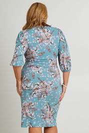 Model Fiona wearing size 16 of The Printed Knot Waist Detail Dress in colour Fiori (Blue), from the back