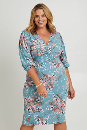 Model Fiona wearing size 16 of The Printed Knot Waist Detail Dress in colour Fiori (Blue), from the front, cropped image