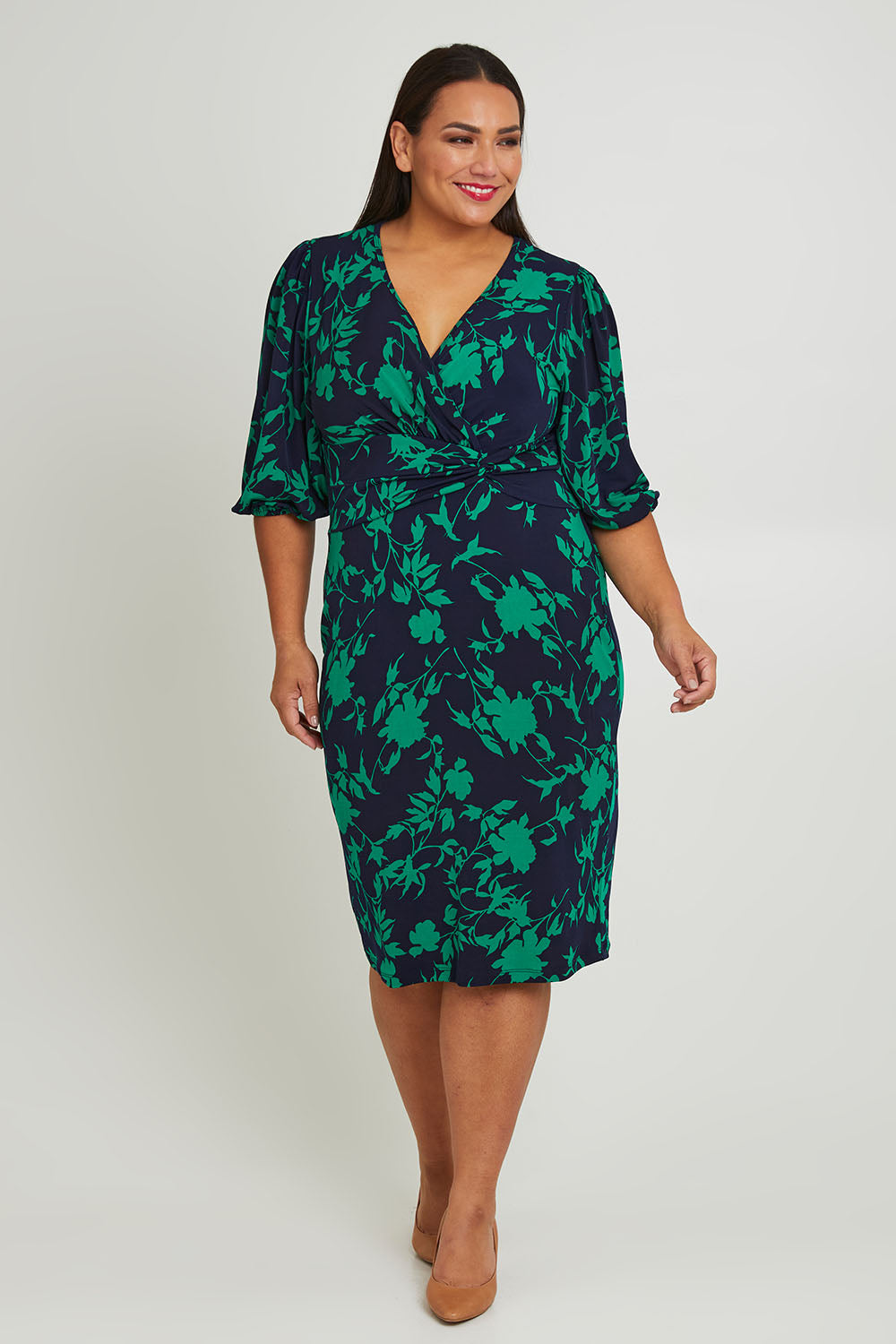 Model Ashleigh wearing size 16 of The Printed Knot Waist Detail Dress in colour Greenfleur (Green), from the front, showing the whole outfit