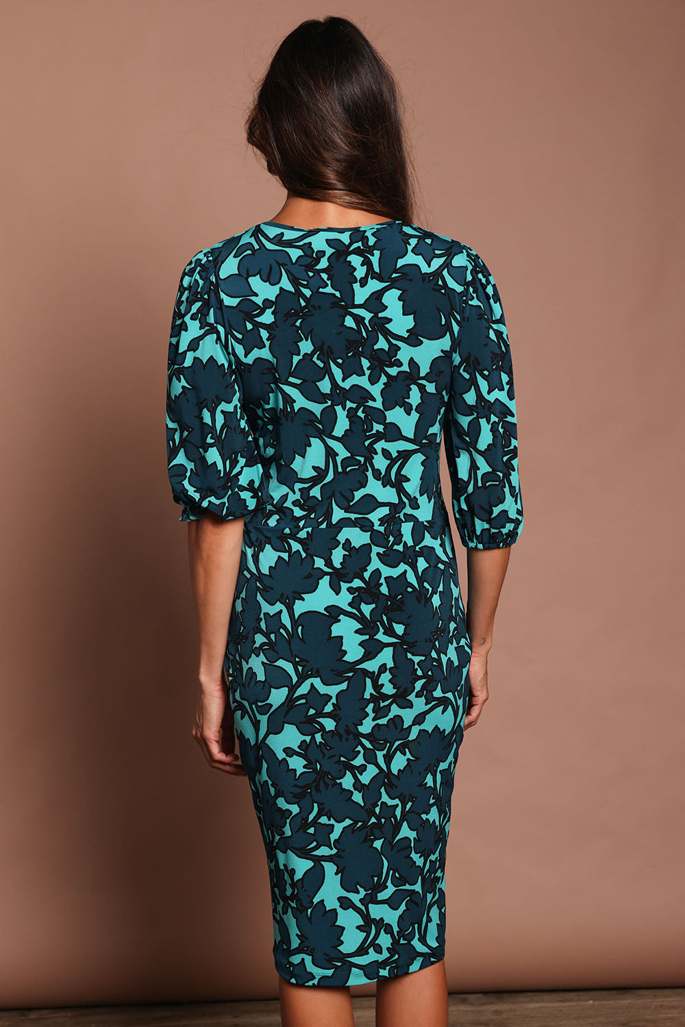 Model Amanda wearing size 10 of The Printed Knot Waist Detail Dress in colour Tealfleur (Green), from the back