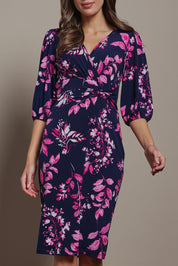 Model Madeline wearing size 10 of The Printed Knot Waist Detail Dress in colour Nightpetal (Blue), from the front, cropped image