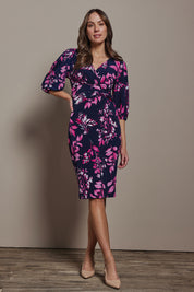 Model Madeline wearing size 10 of The Printed Knot Waist Detail Dress in colour Nightpetal (Blue), from the front, showing the whole outfit