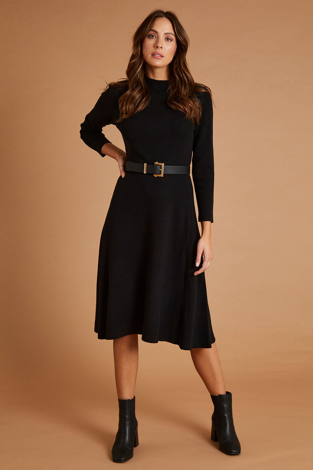 Model Madeline wearing size S of The Fit And Flare Knitted Rib Dress in colour Black (Black), from the front, showing the whole outfit