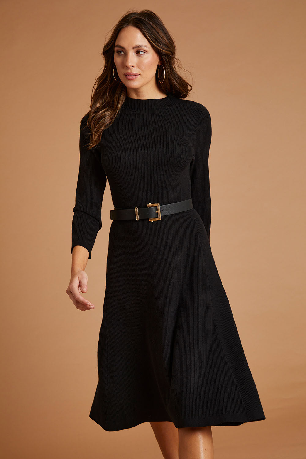 Model Madeline wearing size S of The Fit And Flare Knitted Rib Dress in colour Black (Black), from the front, showing the whole outfit