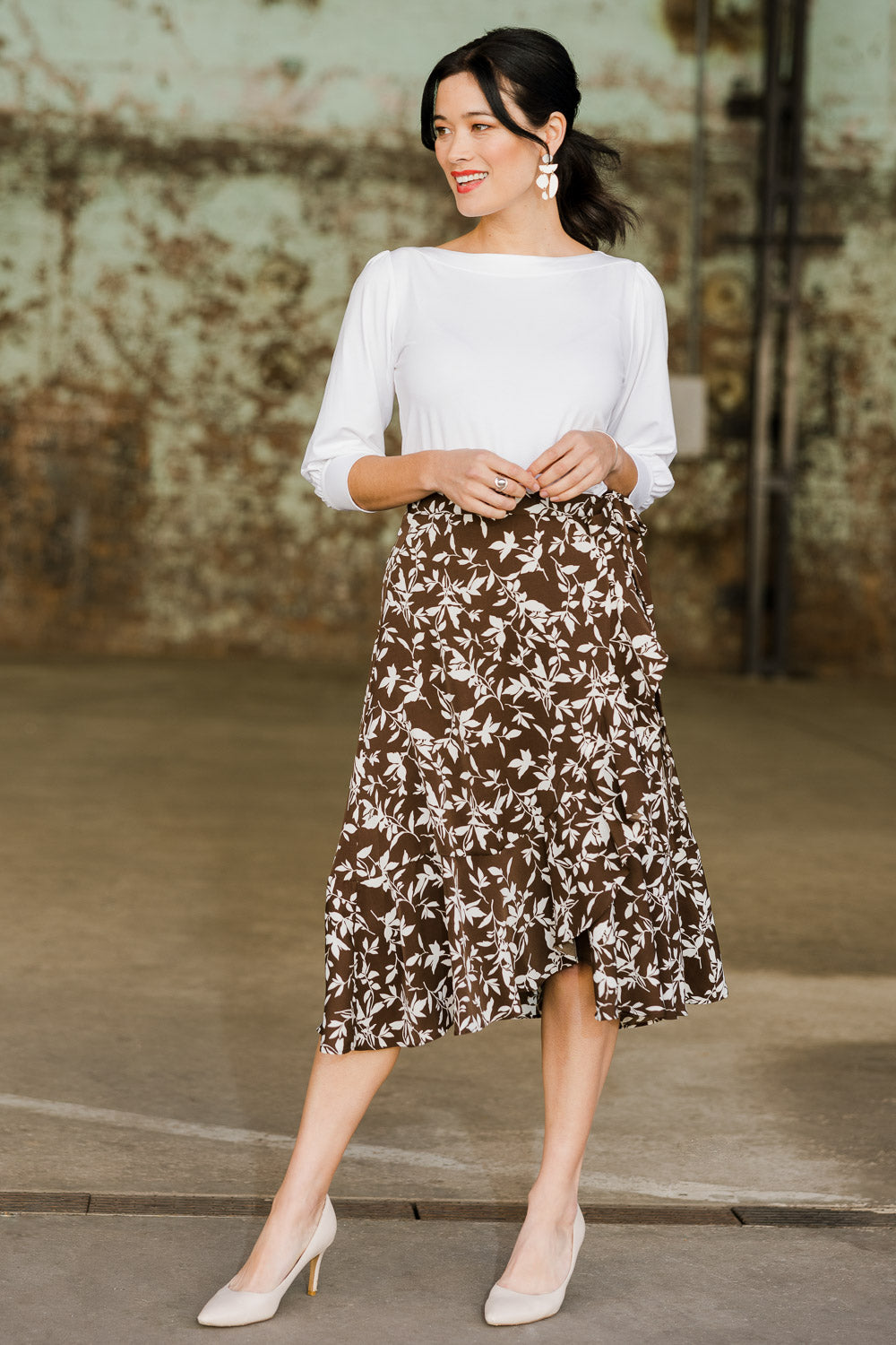 Model Miranda wearing size 10 of The Lined Faux Wrap Ruffle Skirt in colour Vines, from the front, showing the whole outfit