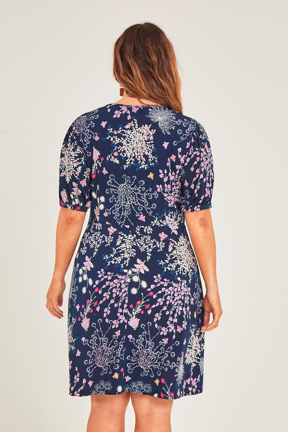 Model Laura wearing size 14 of The Ruched Waist Detail Dress in colour Garden (Blue), from the back