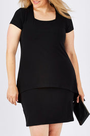 Model Ljubenka wearing size 18 of The Short Sleeve Rita Dress in colour Black (Black), from the front, cropped image