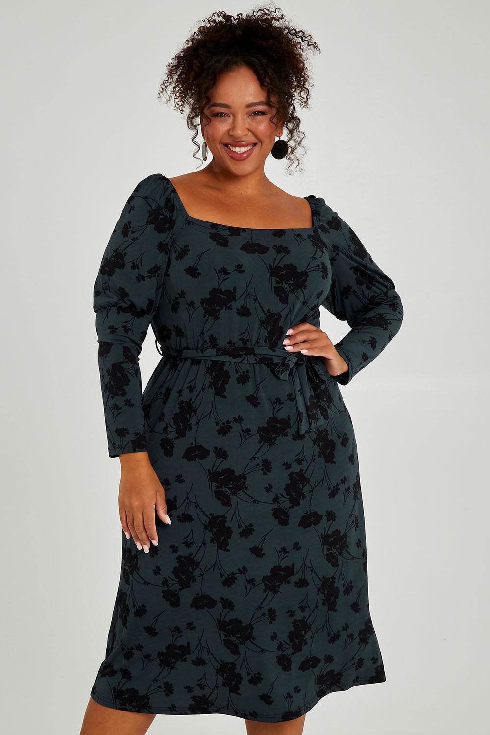 Model Alexis wearing size 16 of The Square Neck Dress in colour Poppy (Green), from the front, cropped image