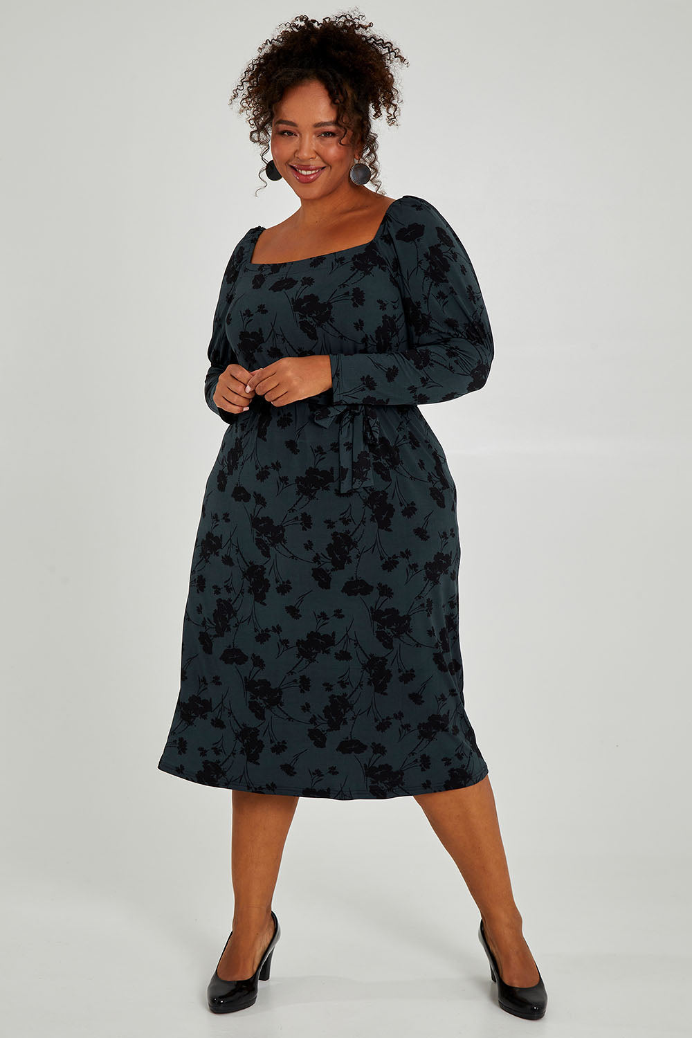 Model Alexis wearing size 16 of The Square Neck Dress in colour Poppy (Green), from the front, showing the whole outfit