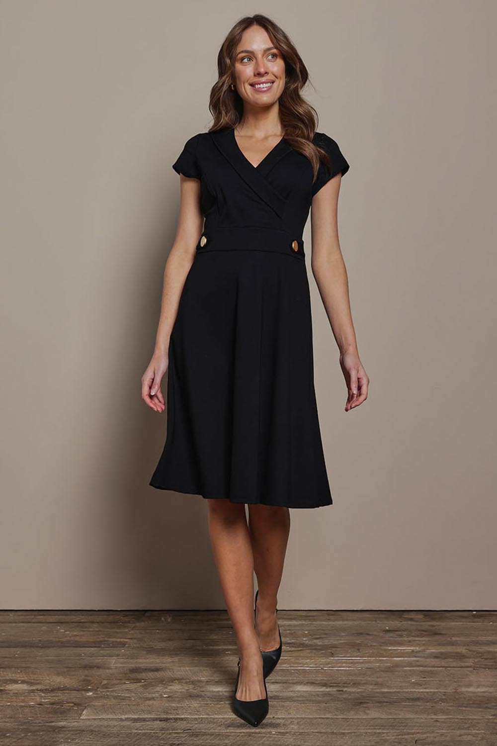 Model Madeline wearing size 10 of The Cap Sleeve Ponte Lapel Dress in colour Black (Black), from the front, showing the whole outfit