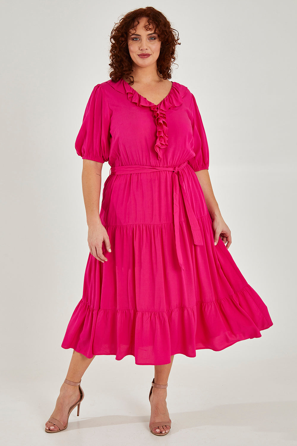 Model Maddy wearing size 16 of The Ruffle Tier Dress in colour Brightpink (Pink), from the front, showing the whole outfit
