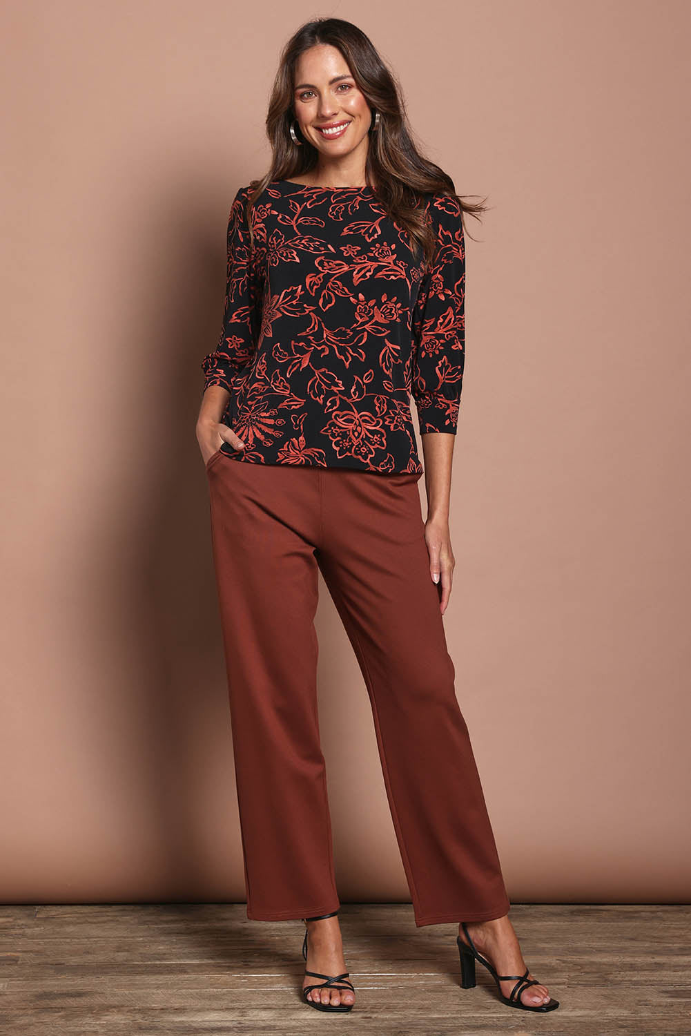 Model Madeline wearing size 10 of The Printed Boat Neck Blouse in colour Emberfleur (Black), from the front, showing the whole outfit
