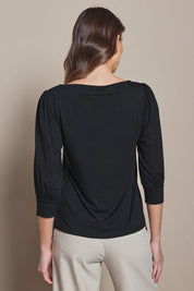 Model Madeline wearing size 10 of The Bamboo Boat Neck Top in colour Black (Black), from the back