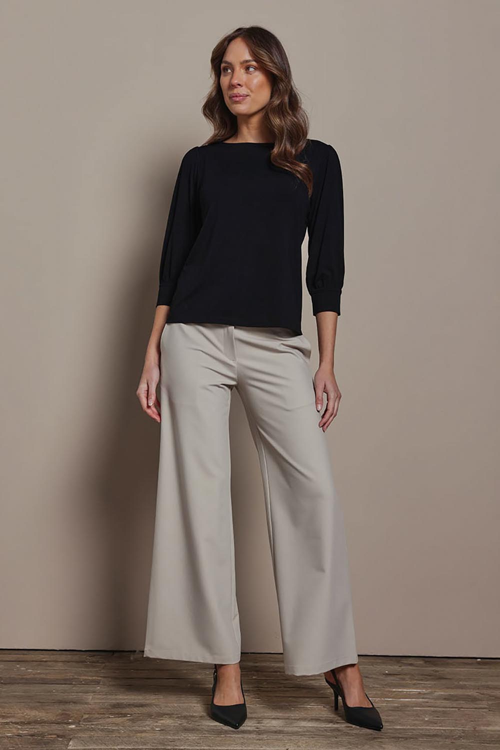 Model Madeline wearing size 10 of The Bamboo Boat Neck Top in colour Black (Black), from the front, showing the whole outfit