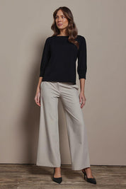 Model Madeline wearing size 10 of The Bamboo Boat Neck Top in colour Black (Black), from the front, showing the whole outfit