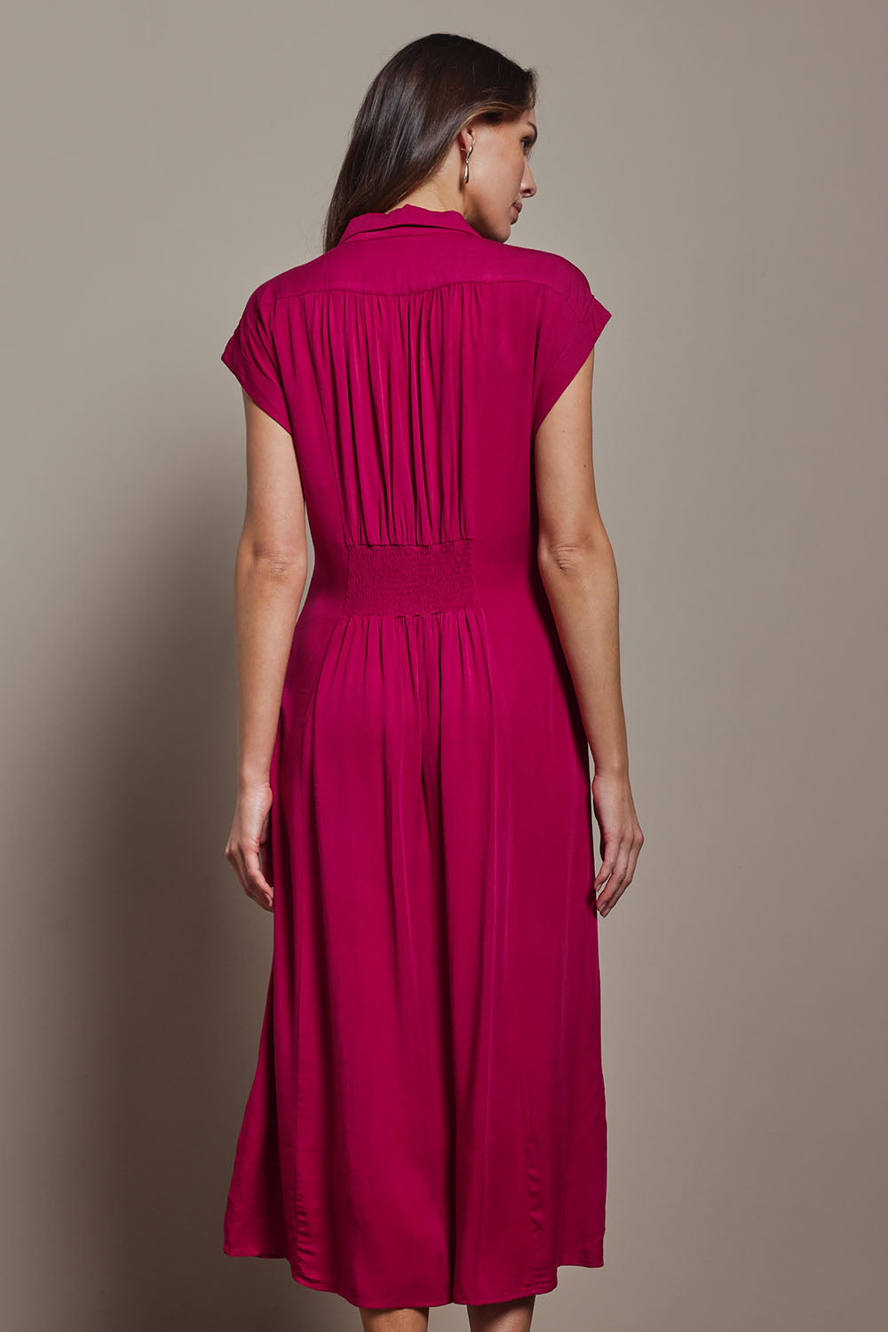 Model Madeline wearing size 10 of The Shirred Waist Detail Dress in colour Raspberry (Red), from the back