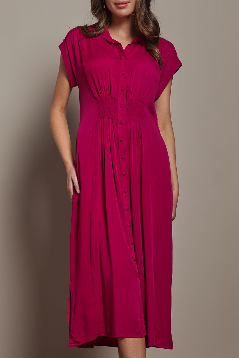 Model Madeline wearing size 10 of The Shirred Waist Detail Dress in colour Raspberry (Red), from the front, cropped image
