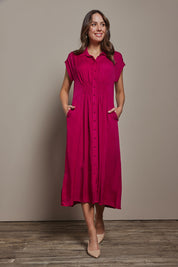 Model Madeline wearing size 10 of The Shirred Waist Detail Dress in colour Raspberry (Red), from the front, showing the whole outfit