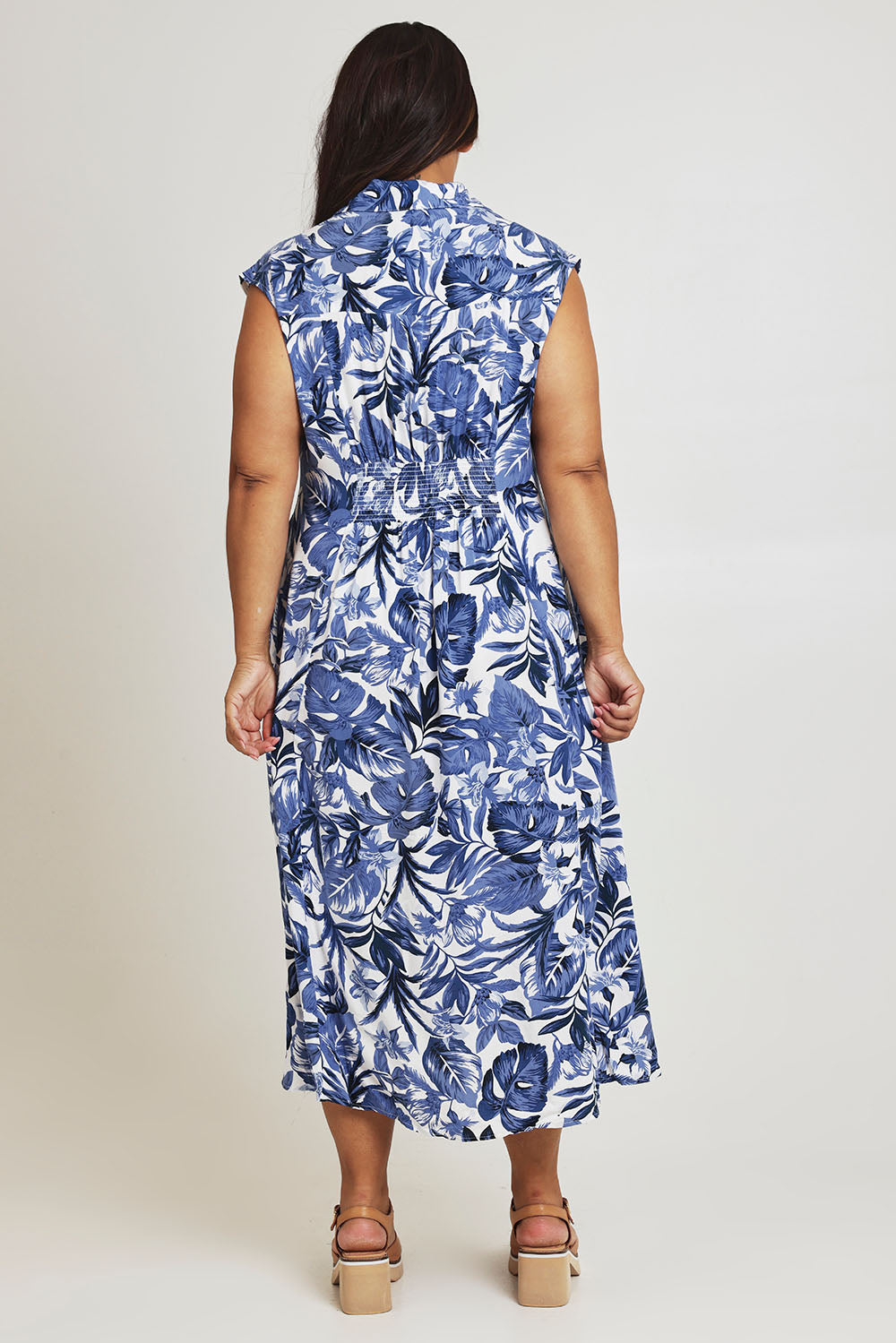Model Ashleigh wearing size 16 of The Shirred Waist Button Through Dress in colour Tropics (Blue), from the back