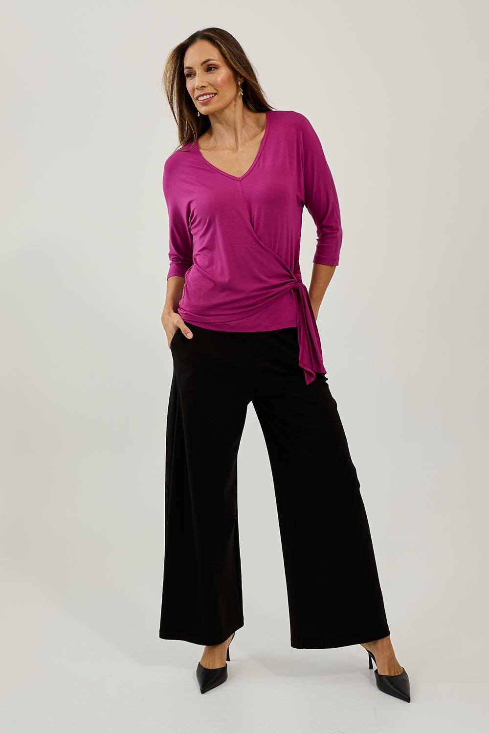 Model Amanda wearing size 10 of The Bamboo Tie Waist Top in colour Berry (Pink), from the front, showing the whole outfit