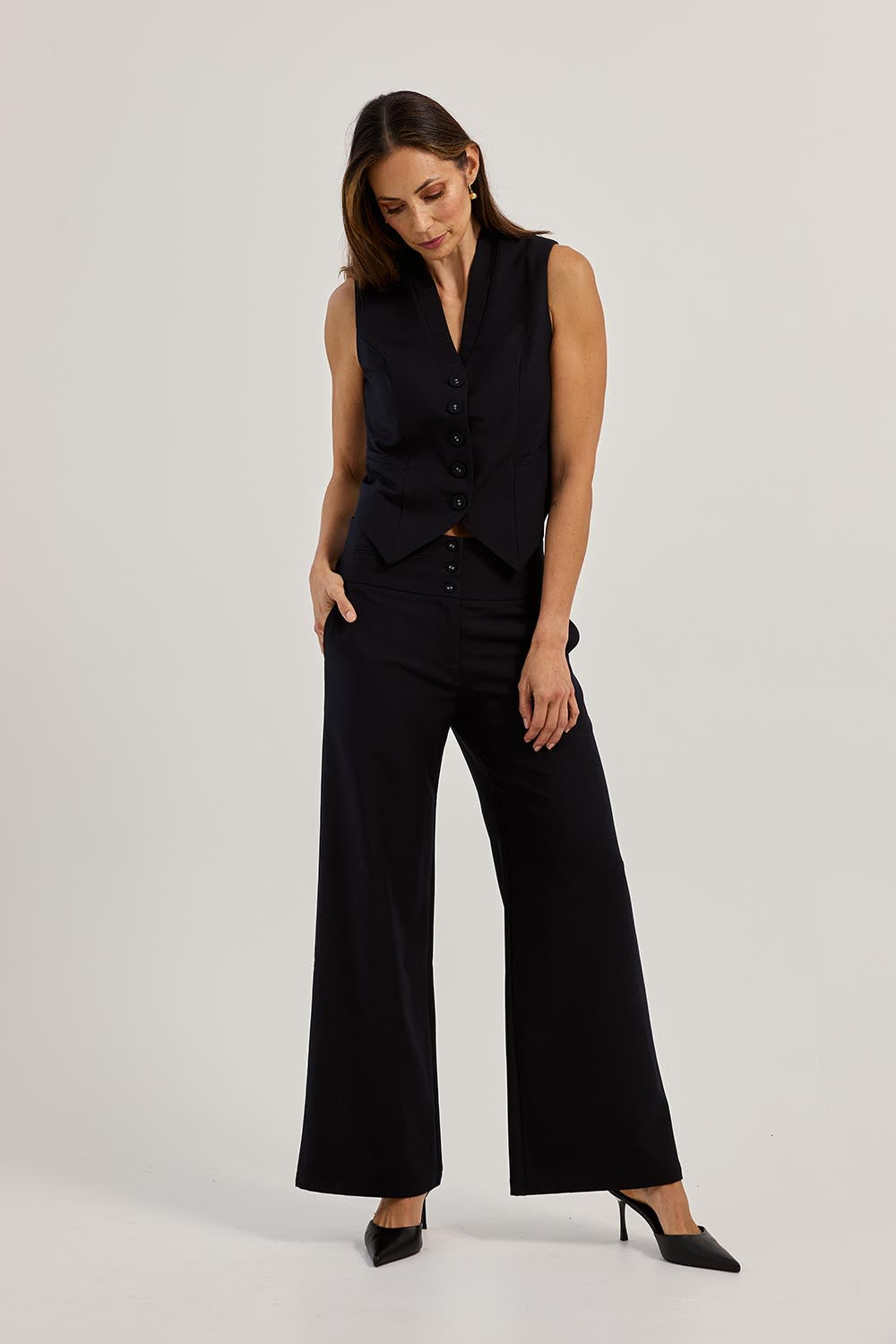 Model Amanda wearing size 10 of The Tailored Vest in colour Ink (Blue), from the front, showing the whole outfit