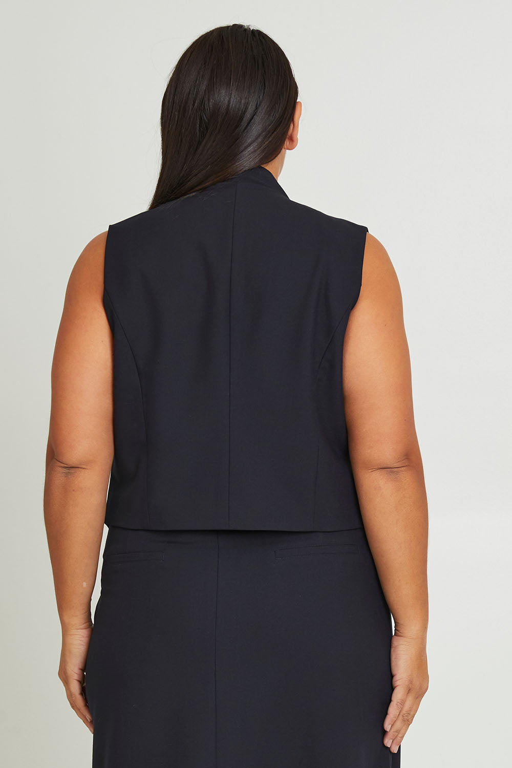 Model Ashleigh wearing size 16 of The Tailored Vest in colour Ink (Blue), from the back