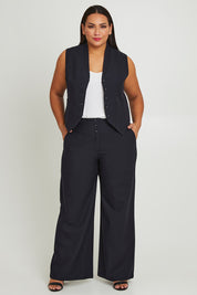Model Ashleigh wearing size 16 of The Tailored Pant in colour Ink (Blue), from the front, showing the whole outfit