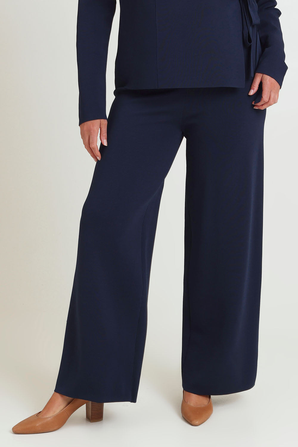 Model Chanel wearing size XL of The Milano Knit Pull On Pant in colour Darknavy (Blue), from the front, cropped image