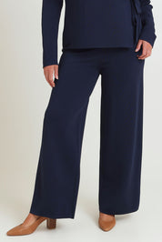 Model Chanel wearing size XL of The Milano Knit Pull On Pant in colour Darknavy (Blue), from the front, cropped image