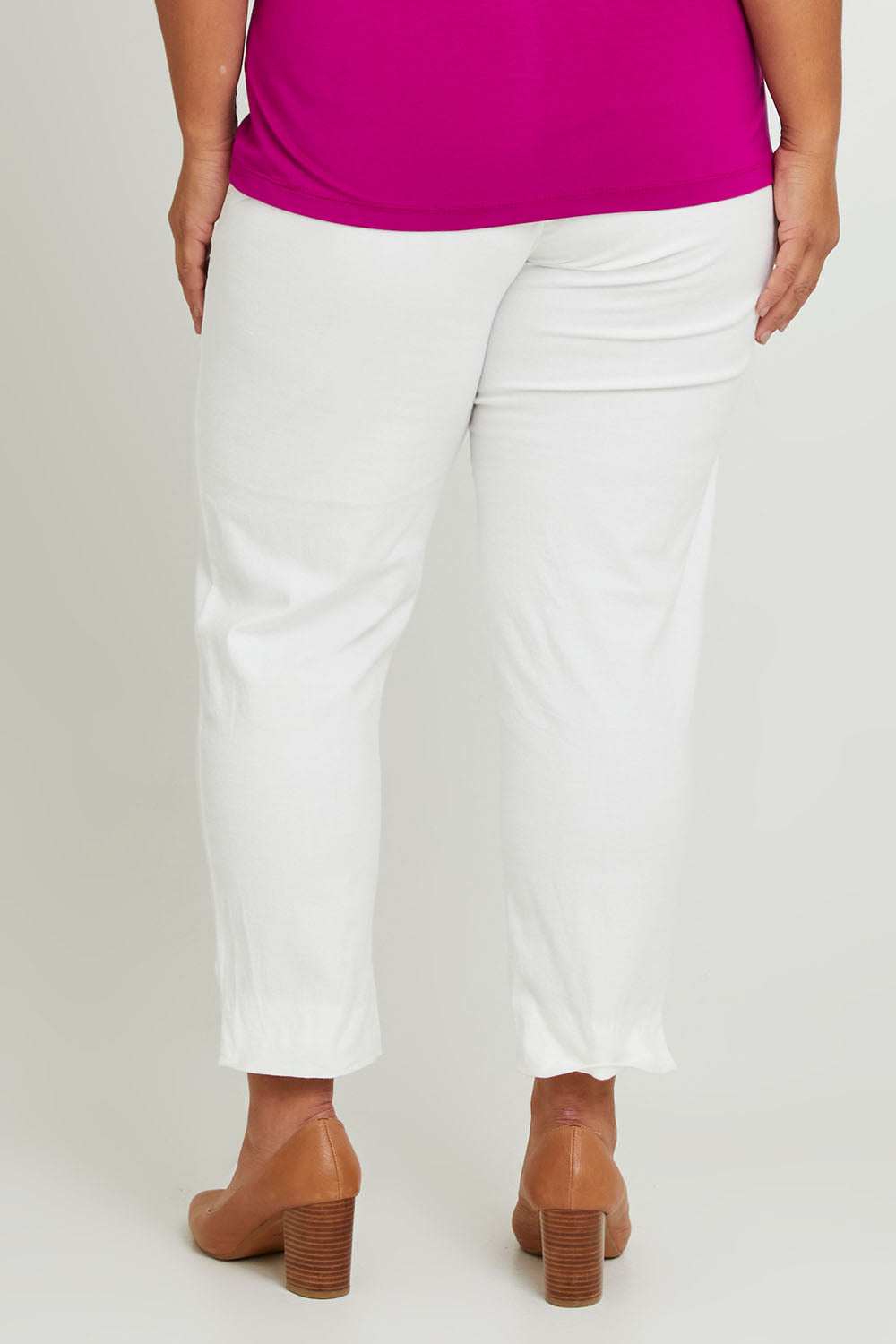Model Ashleigh wearing size 16 of The 7/8 Cotton Stretch Pull On Pant in colour Snow (White), from the back