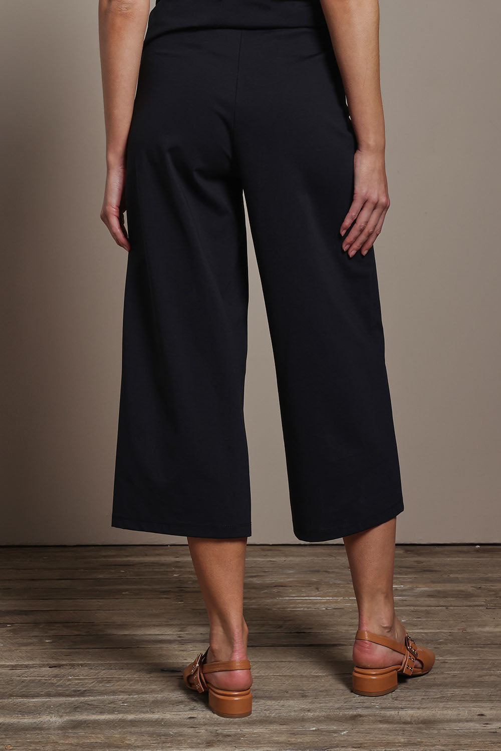 Model Madeline wearing size 10 of The Cotton Blend Pull On Culotte in colour Black (Black), from the back