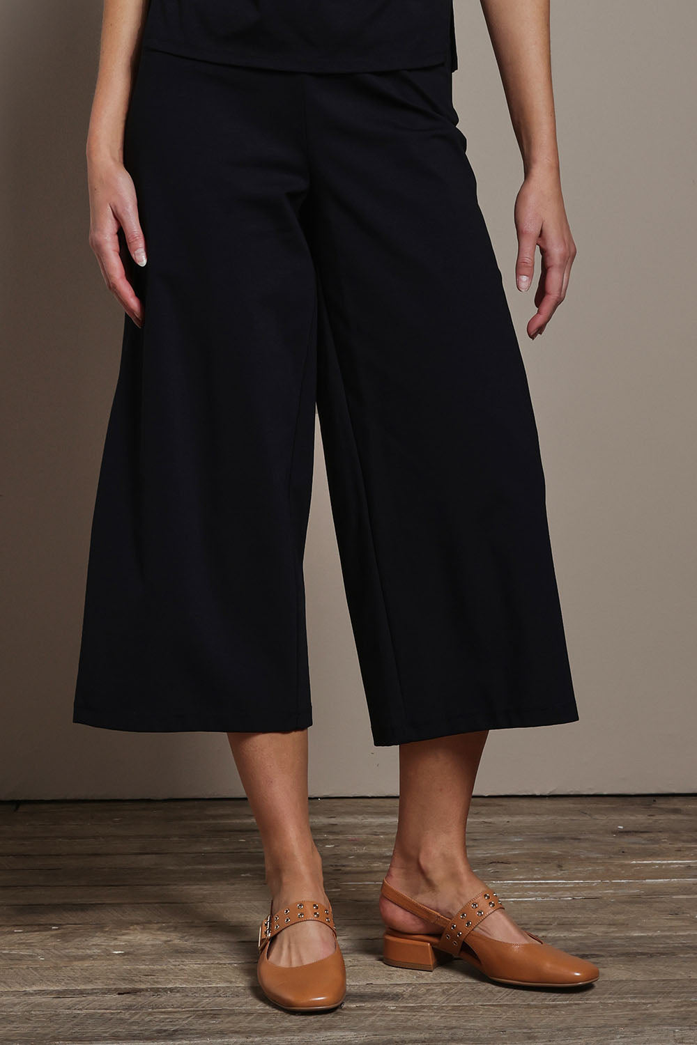 Model Madeline wearing size 10 of The Cotton Blend Pull On Culotte in colour Black (Black), from the front, cropped image