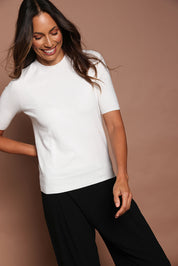 Model Amanda wearing size S of The Seamless Soft Crew Neck Knit in colour Snow (White), from the front, cropped image