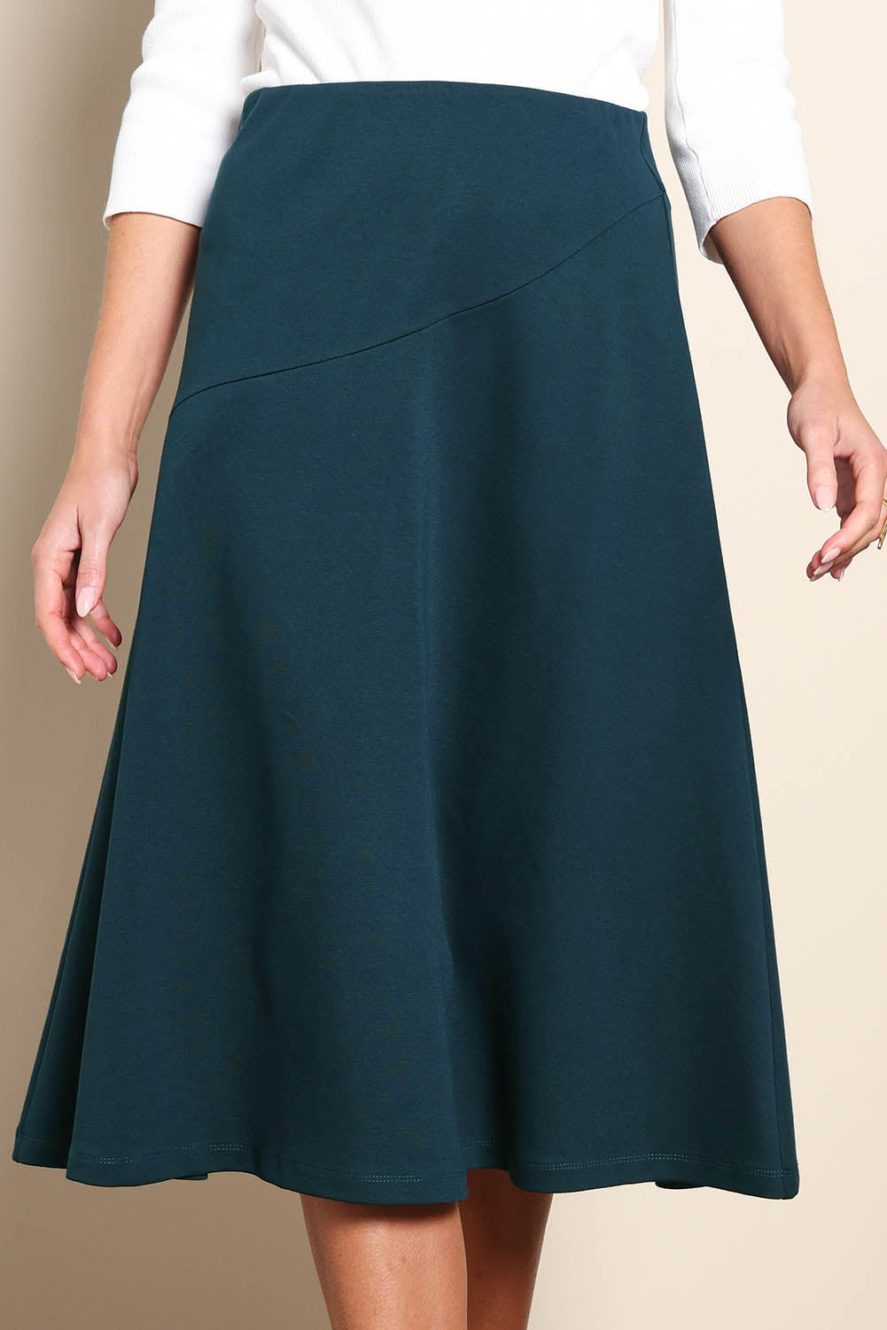 Model Madelinec wearing size 10 of the The Ponte Curve Seam Pull On Skirt – Lagoon in colour Lagoon, in a cropped view