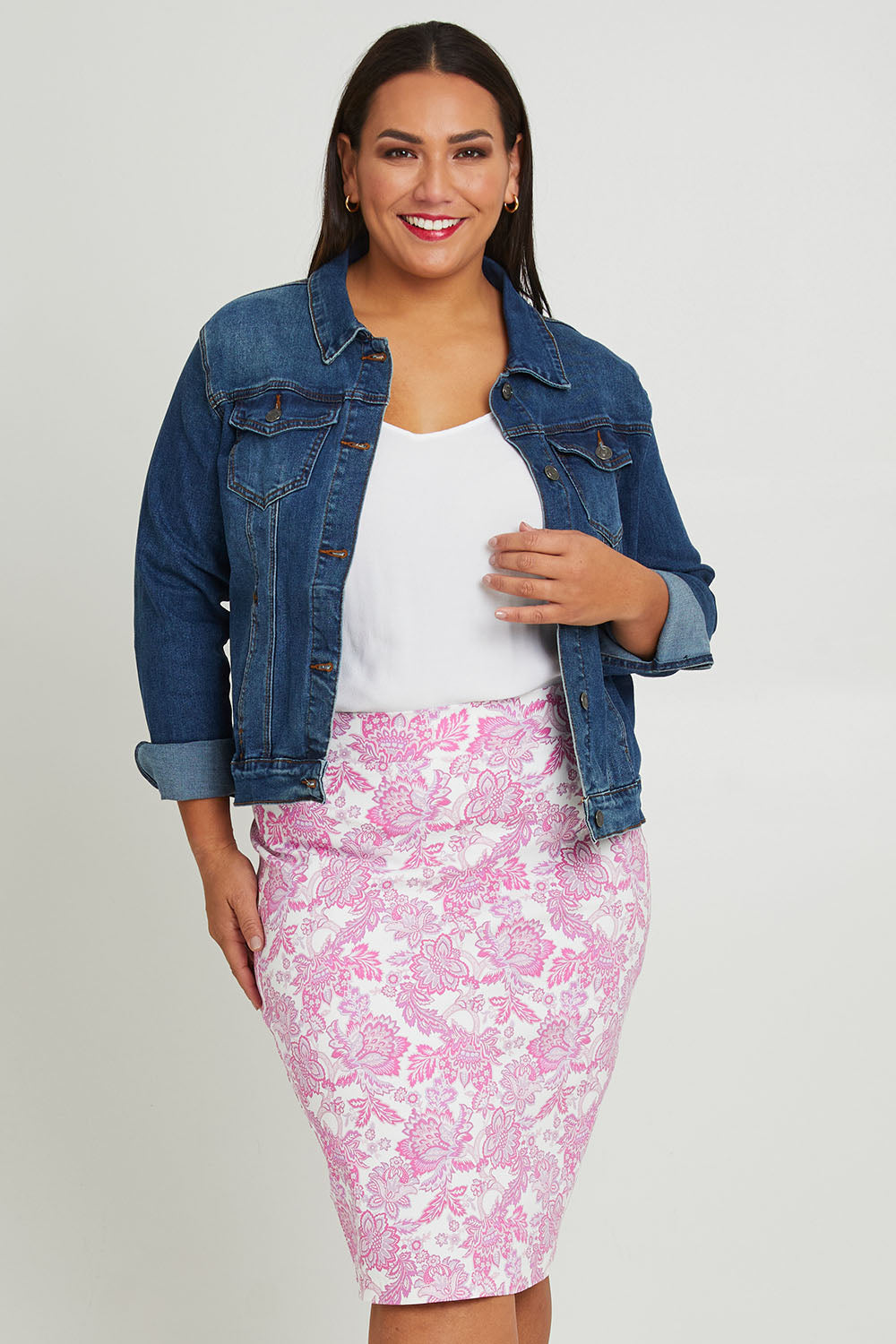 Model Ashleigh wearing size 16 of The Tube Skirt in colour Pinkfleur (Pink), from the front, cropped image