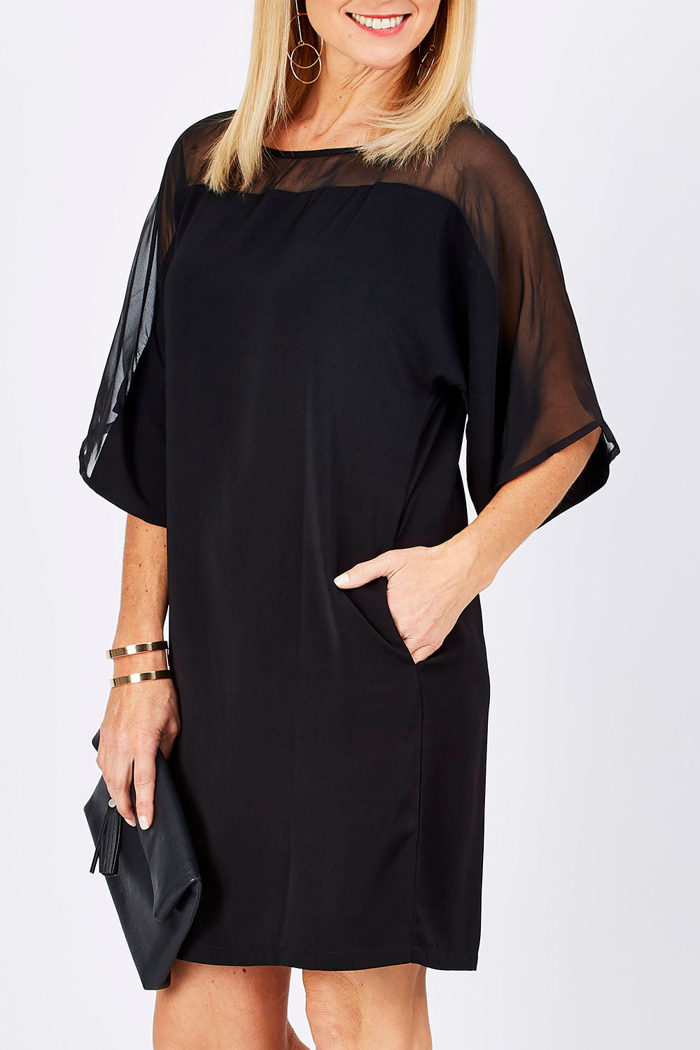 Model Monique wearing size 10 of The Chiffon Mesh Detail Dress in colour Black (Black), from the front, cropped image
