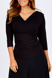 Model Laura wearing size 12 of The Reversible Cowl Neck Top in colour Black (Black), from the front, cropped image