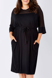 Model Mae wearing size 18 of the Belle Mesh Yoke Dress in colour Back (Black), from the front, cropped image