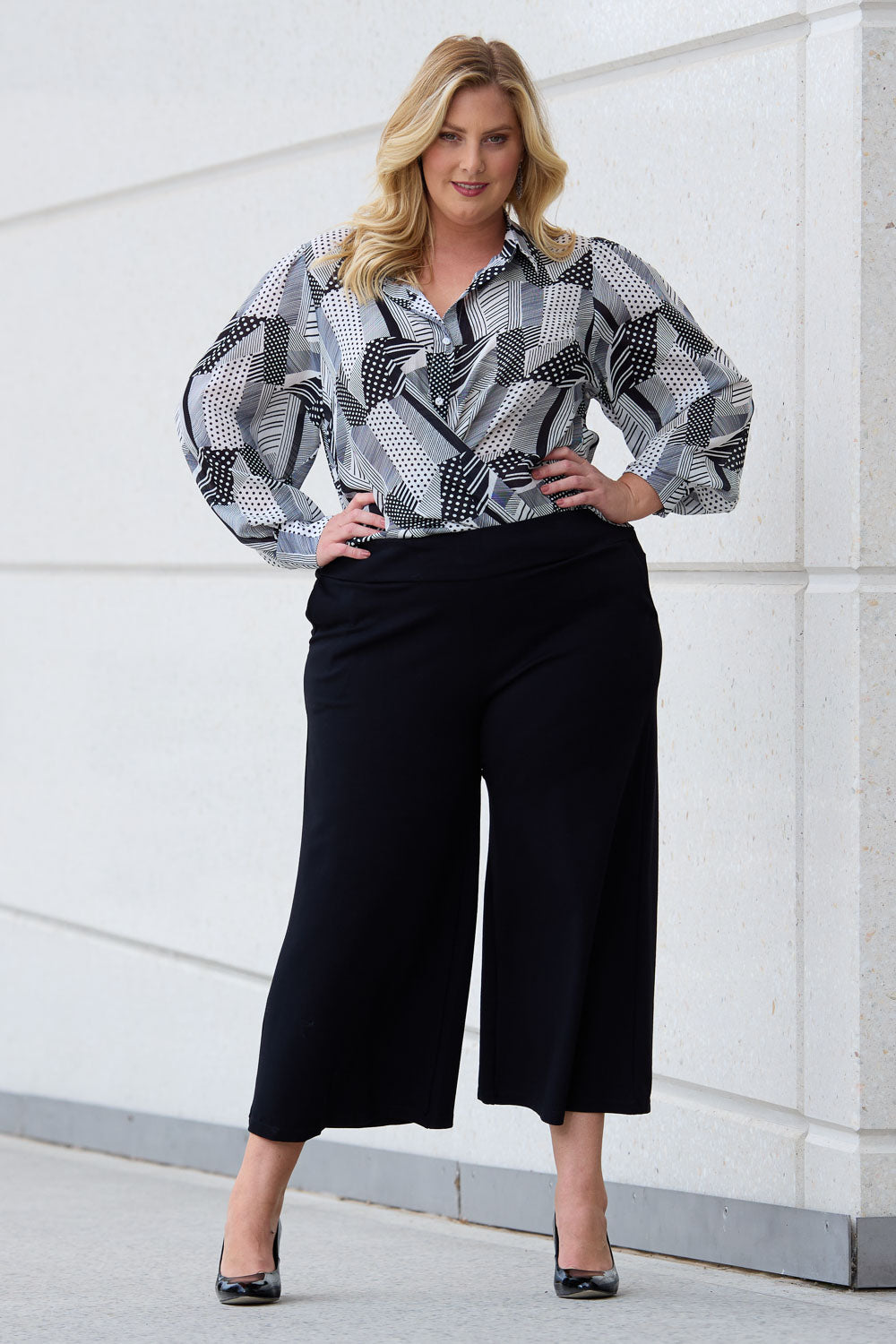 Model Caitlin wearing size 18 of the Belle Palazzo Ponte Crop in colour Black (Black), from the front, showing the whole outfit