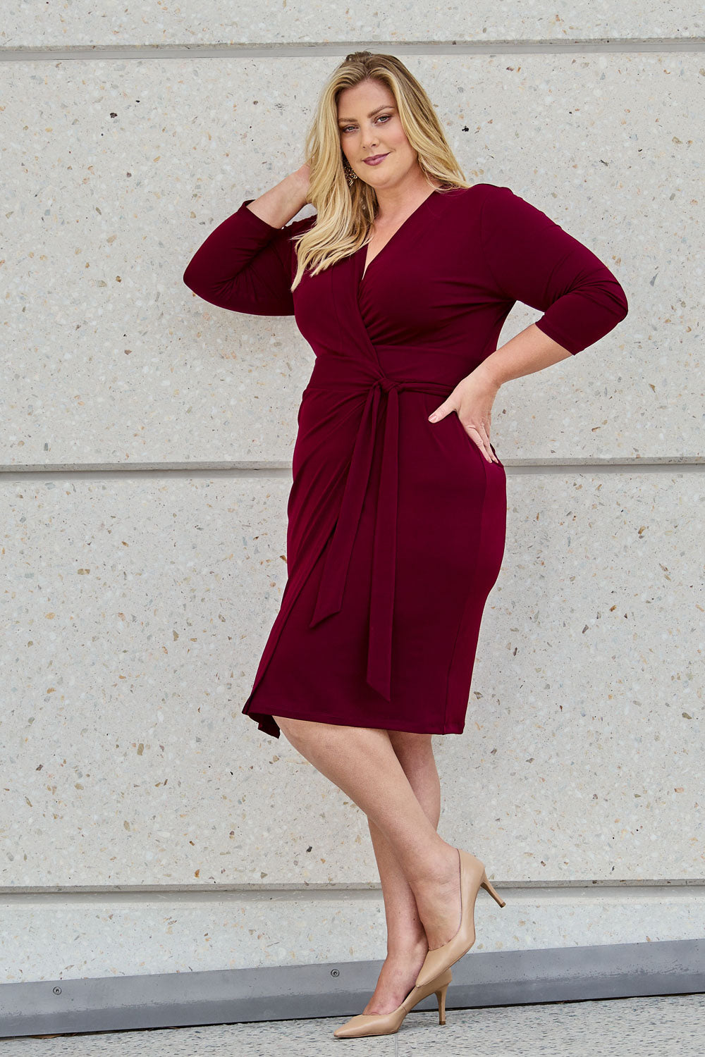 Model Caitlin wearing size 18 of the Belle Basic Wrap Dress in colour Shiraz (Purple), from the front, showing the whole outfit