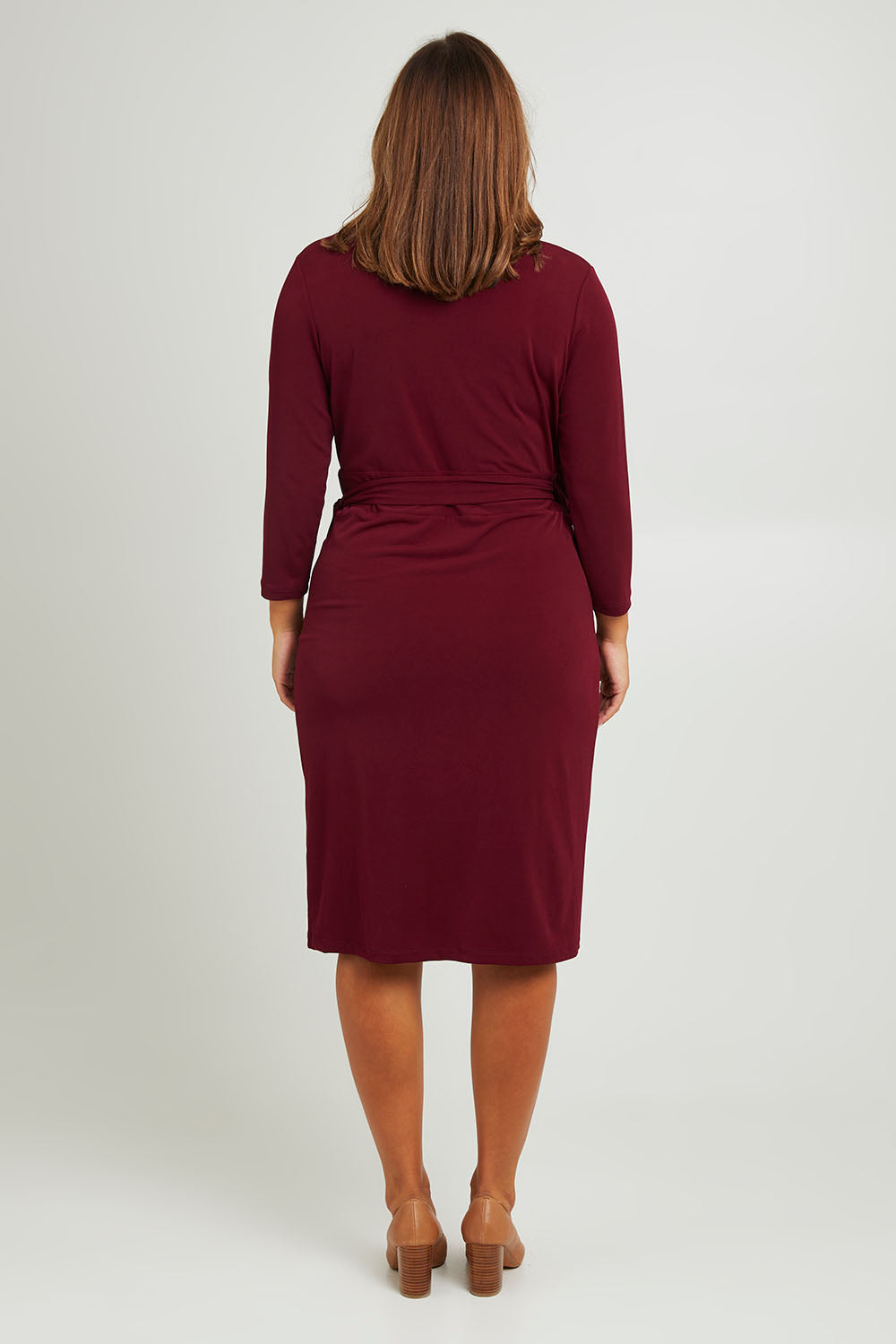 Model Monique wearing size 14 of the Belle Basic Wrap Dress in colour Shiraz (Purple), from the back