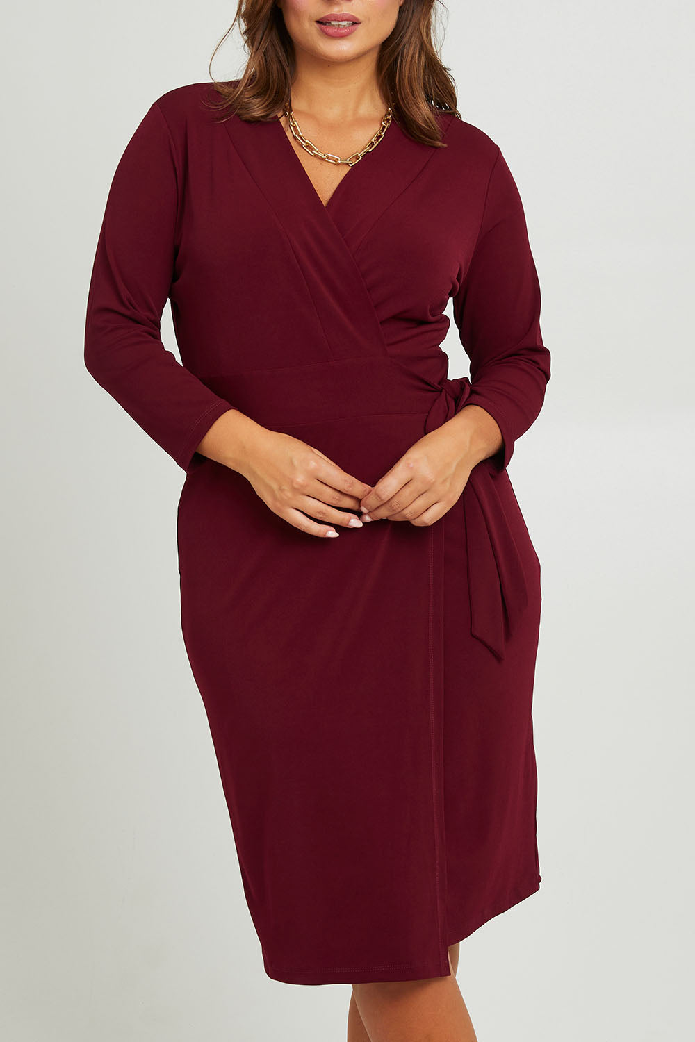 Model Monique wearing size 14 of the Belle Basic Wrap Dress in colour Shiraz (Purple), from the front, cropped image