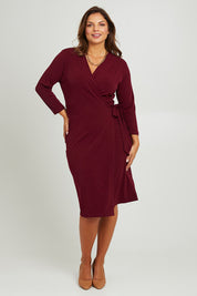 Model Monique wearing size 14 of the Belle Basic Wrap Dress in colour Shiraz (Purple), from the front, showing the whole outfit