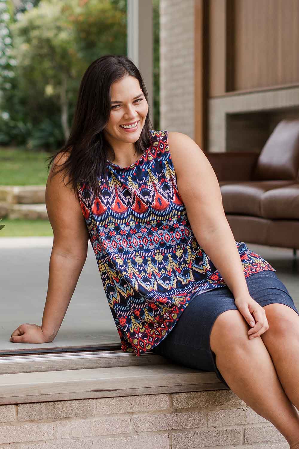 Model Lauren wearing size 16 of the Belle Aztec Trapeze Top in colour Aztec (Red), from the front, showing the whole outfit